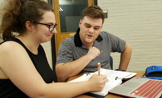 male student providing writing support/mentoring to female student