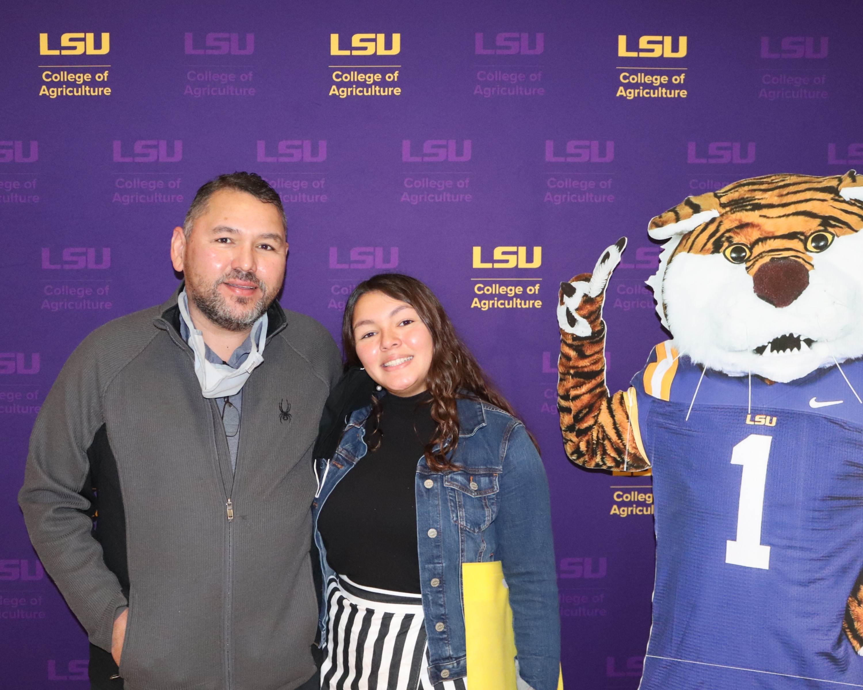 student and parent smile beside cut out of Mike