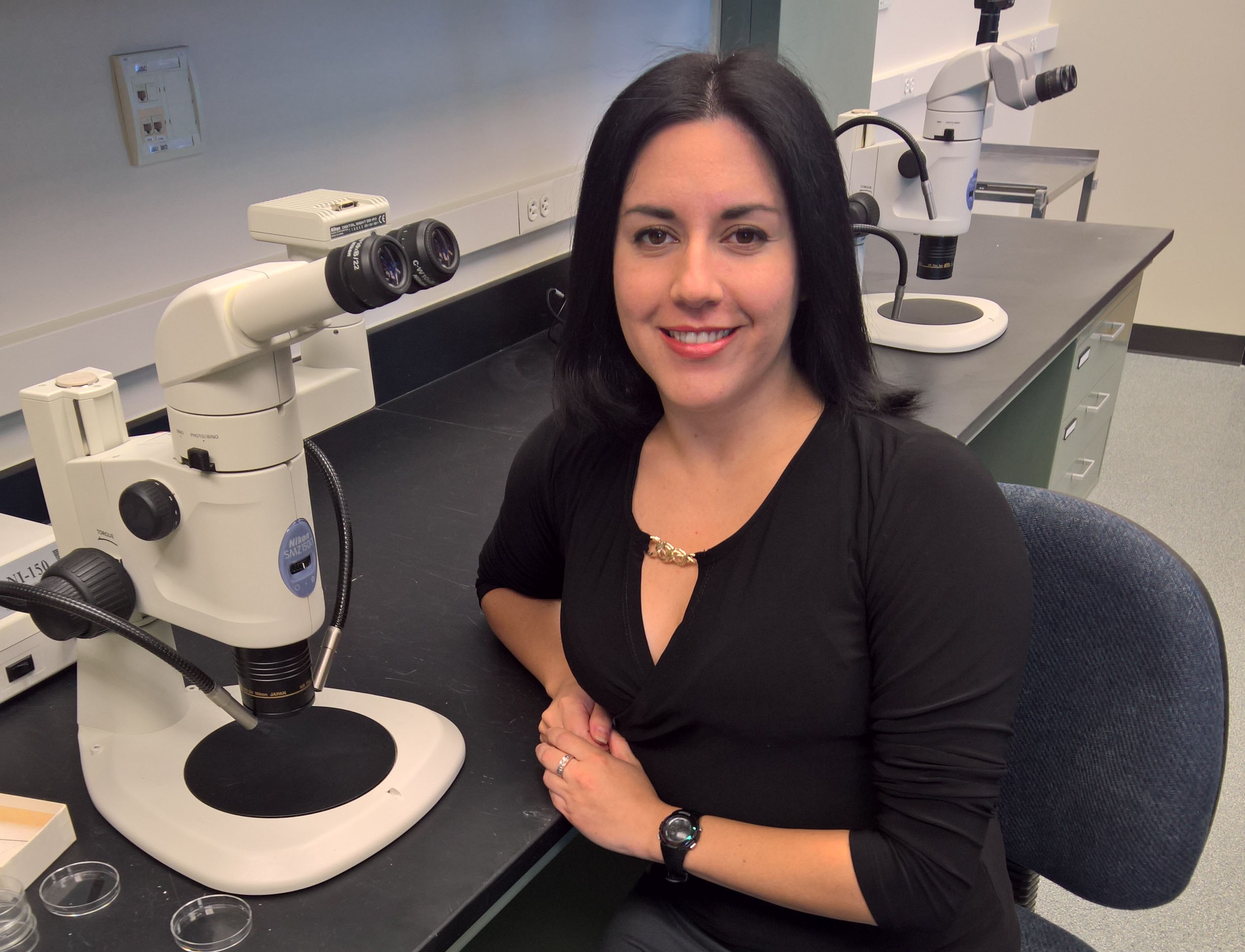 Paula Castillo at microscope in lab