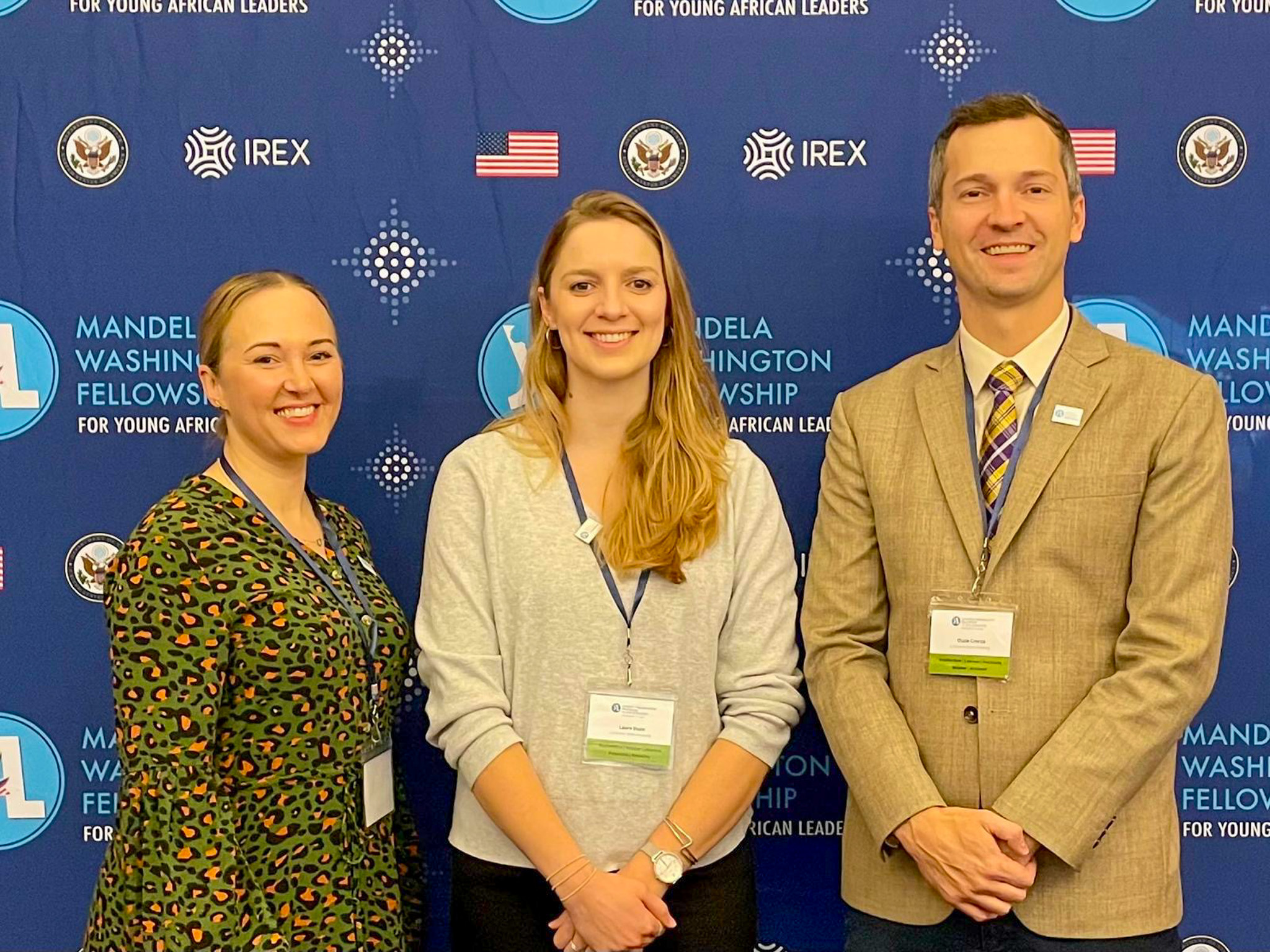 three people in professional wear smile together