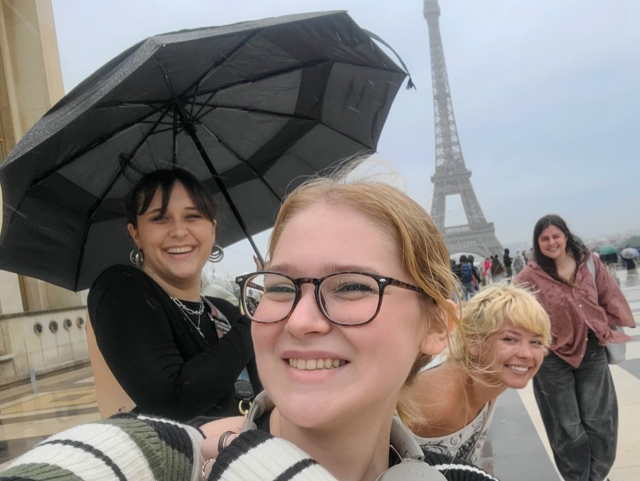 students smile in front of the Eiffel Tower