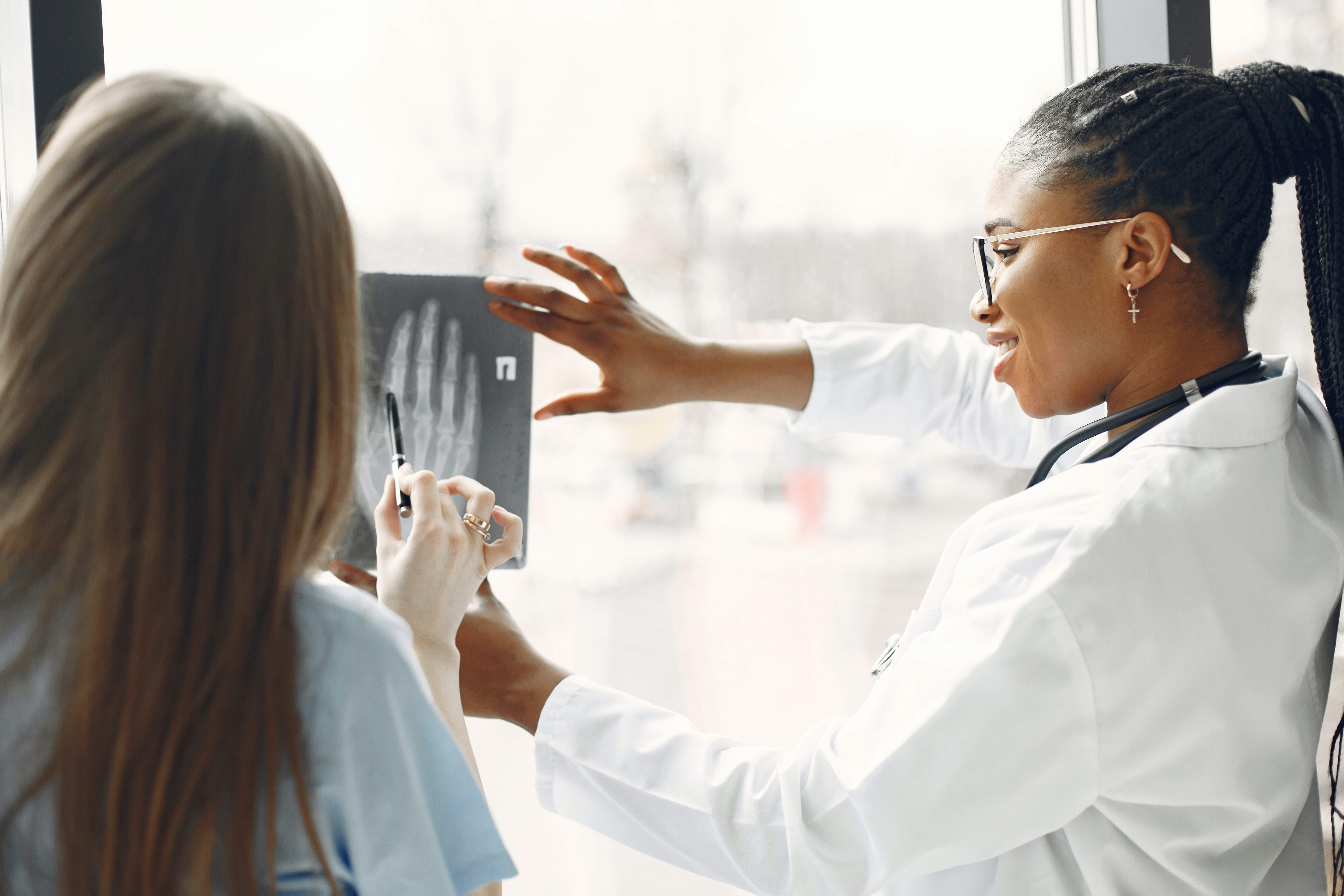 provider and student look at an xray of a hand